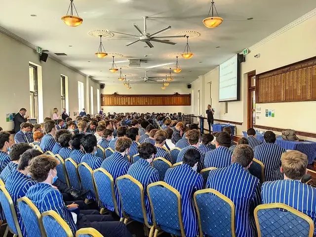 Students in blazers at a Simple Six presentation